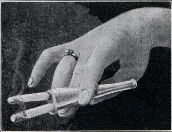 A woman's hand holding a cigarette showcasing one of the ridiculously strange but cool inventions from the early 1900’s.