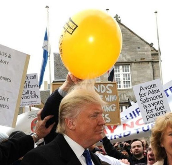 A group of people holding balloons and signs, expressing their enthusiasm for Trolls Live.