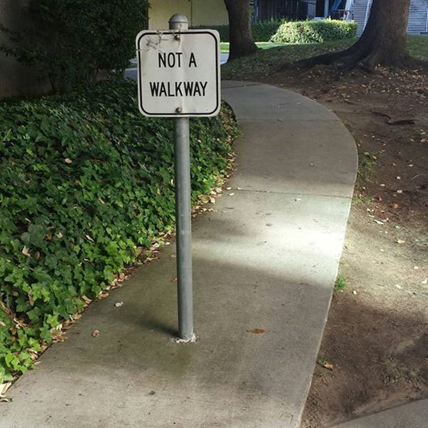 A sidewalk adorned with a sign that amusingly states 