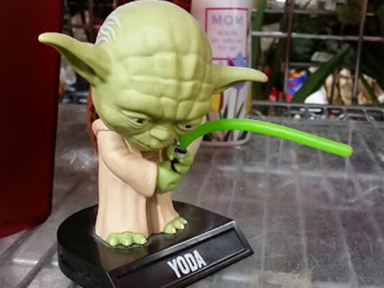 A Star Wars Yoda figurine wielding a green lightsaber available at thrift stores.