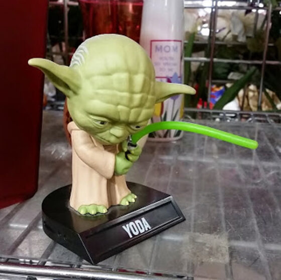 A Star Wars Yoda figurine wielding a green lightsaber available at thrift stores.