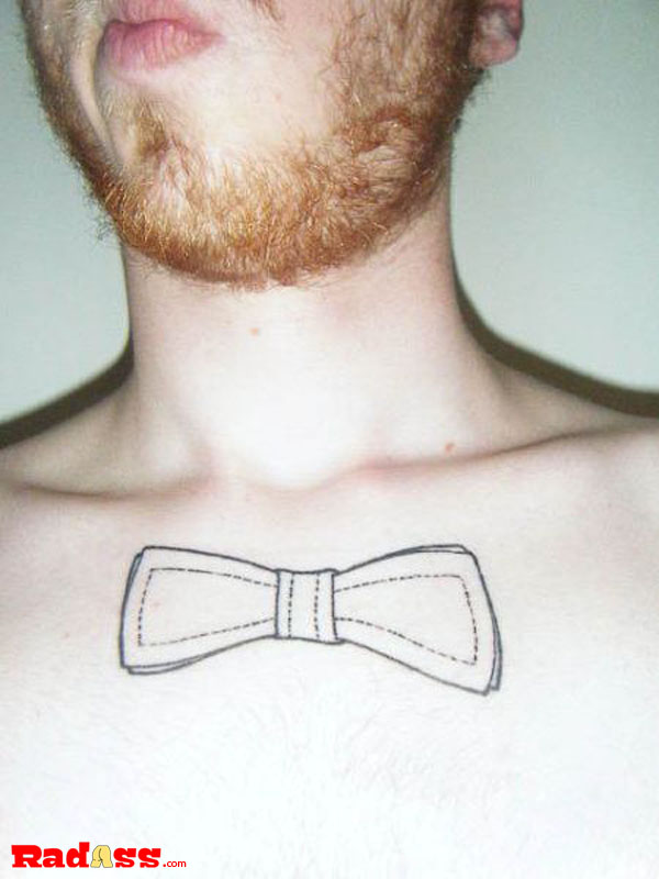 A man proudly displaying a bow tie tattoo on his chest.