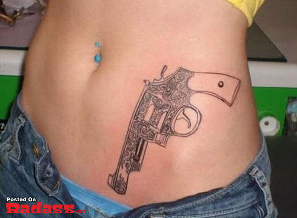 A woman packing a gun tattoo on her stomach.