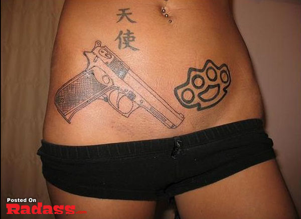 A woman sporting a gun tattoo on her stomach with 32 People That Are Packing For Life.