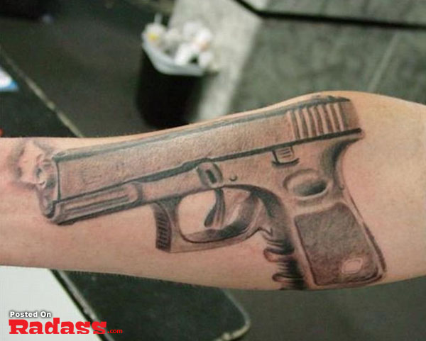 A forearm tattoo featuring a gun design.