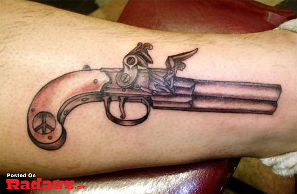 A man's leg showcasing a gun tattoo.