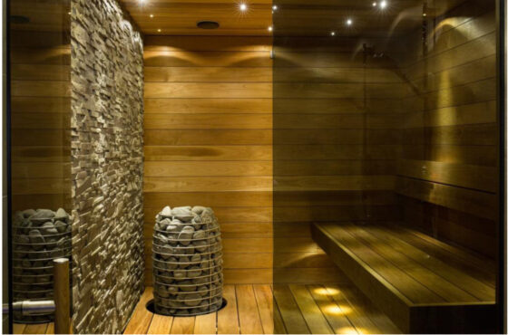 A sauna room with wooden walls and a stone bench provides a cool and relaxing retreat, even amid COVID.