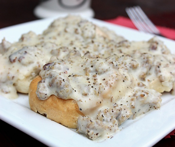 Sausage gravy on a comforting white plate with a fork.