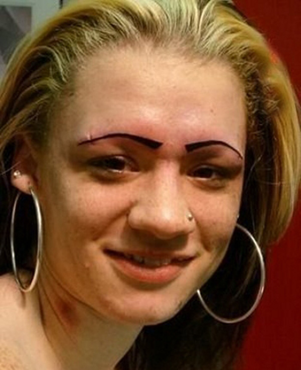 A woman with everlasting eyebrow tattoos posing for a picture, showcasing what a bad decision looks like.