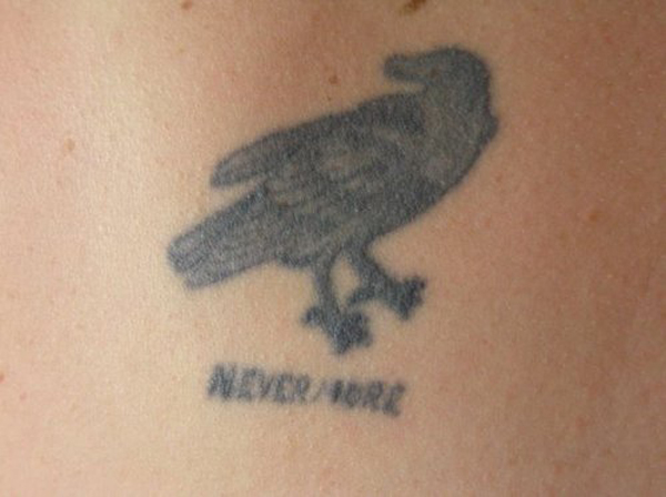 A regrettable tattoo of a crow permanently inked on a woman's back.
