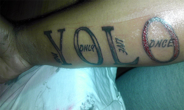 A person with a regrettable yolo tattoo, showcasing what a bad decision looks like... forever.