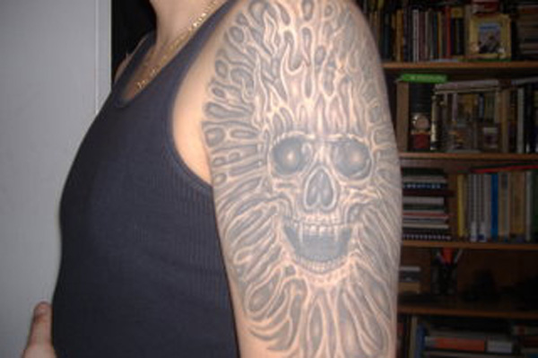 A man with a permanent skull tattoo on his sleeve showcases what a bad decision looks like for eternity.