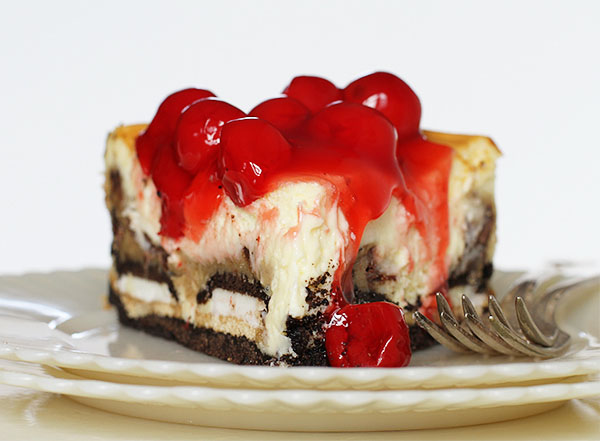 A decadent slice of cheesecake garnished with plump cherries.