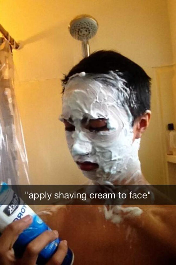 A man creating a hilarious Snapchat moment while applying shaving cream to his face.