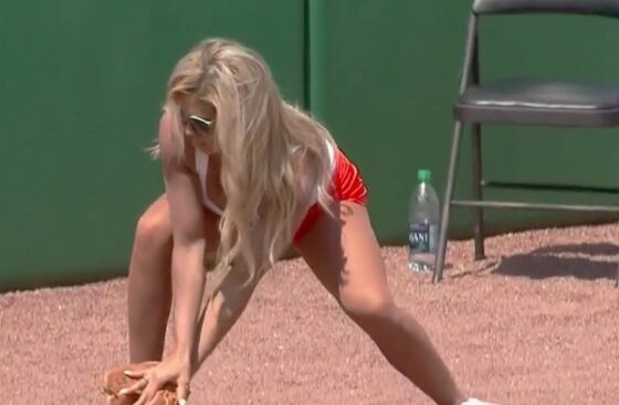 A Hooters babe gracefully fails to catch a baseball.
