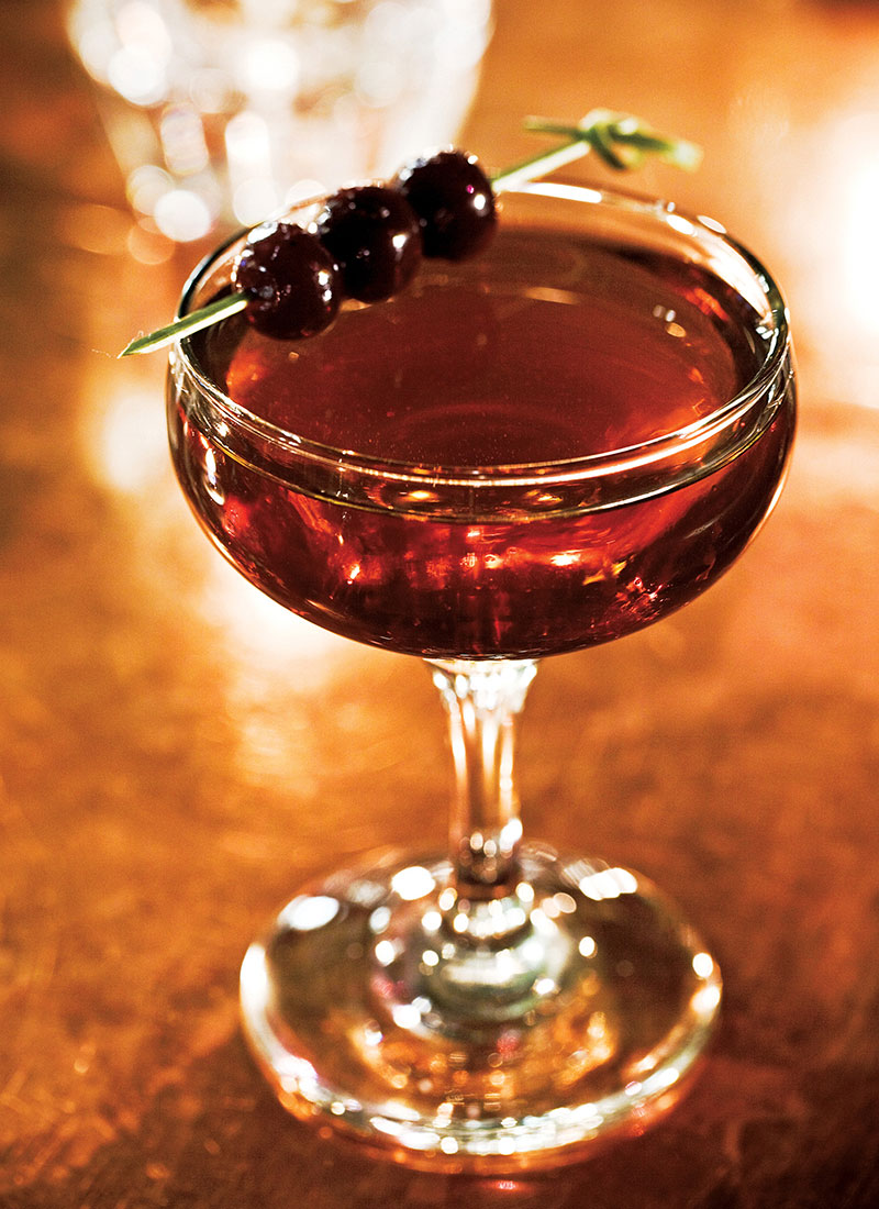 A manly cocktail topped with a cherry, ideal for sparking bar conversations.