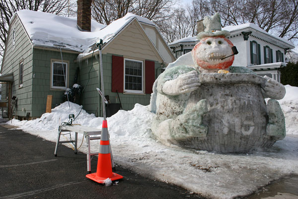 A snowman statue adorns a house.