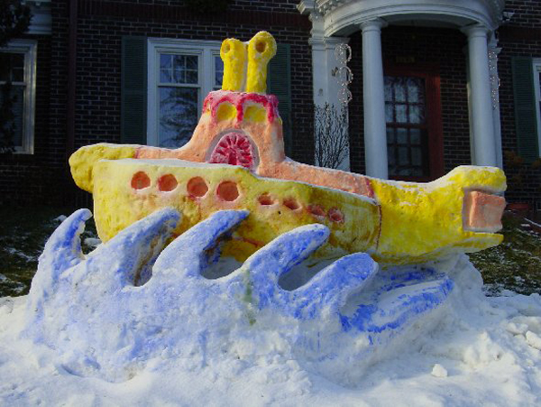 A yellow submarine snow sculpture brings winter joy to a house.