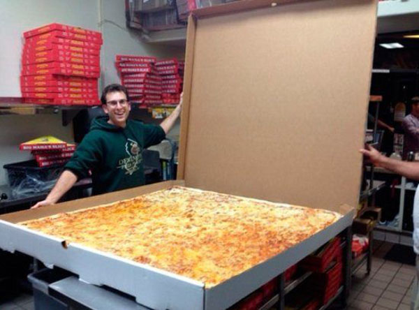 A man tempted by a large pizza in a box, struggling with wants vs. needs.