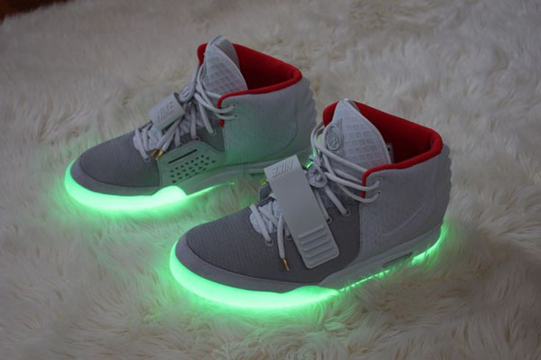 A pair of glow in the dark sneakers on a rug.