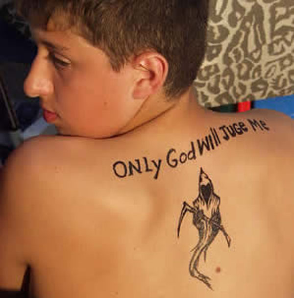 A boy with a powerful tattoo on his back, reminding him that only god will determine his fate.