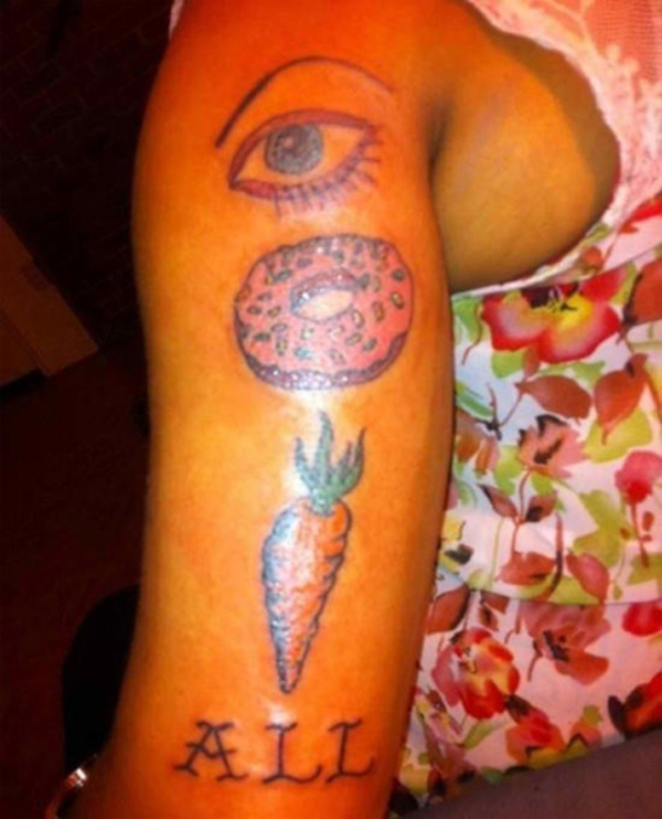 A woman's arm adorned with an eye and carrot tattoo, inspiring a sense of empowerment and positivity in life.