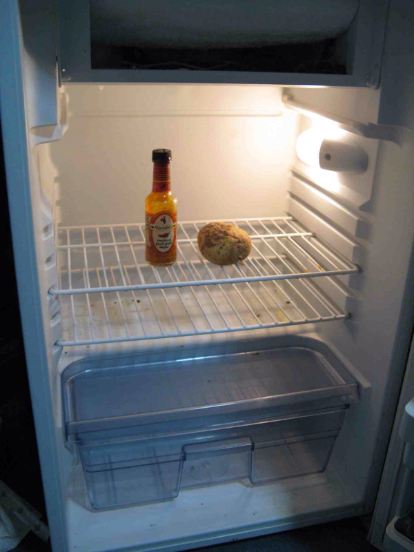 Open refrigerator, bread, hot sauce.