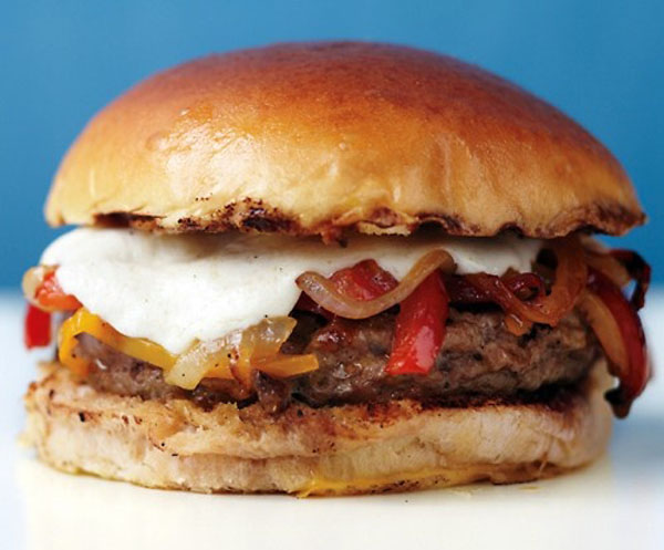 A visually appealing Super Bowl burger topped with peppers and cheese.