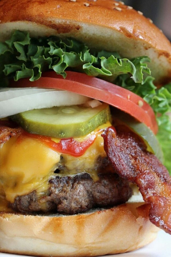 An awesome burger with bacon, lettuce, tomatoes and pickles that is perfect for Super Bowl parties.