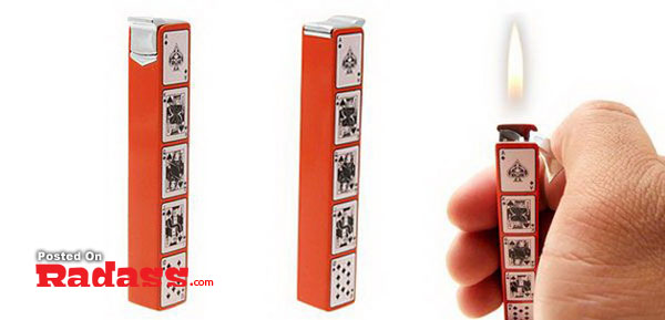 A hand is holding a stylish lighter in front of a red deck of cards.
