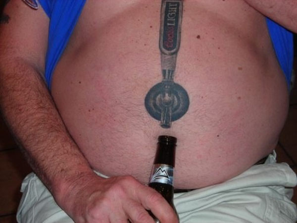 A man with a beer bottle tattoo on his stomach featured in 20 Terrible Tattoos That Will Make You Happy You Are You.