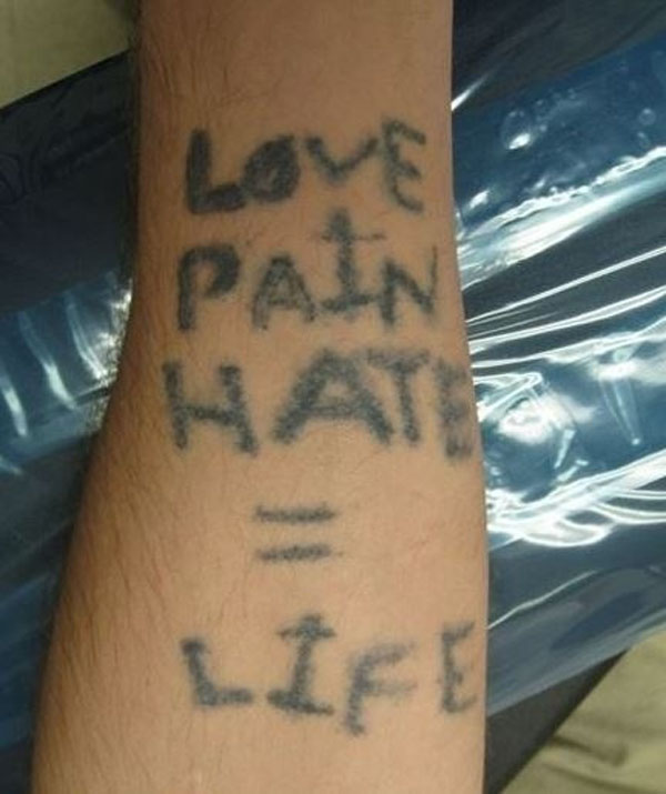 A person's arm with a tattoo that says love pain hate life, showcasing one of the 20 terrible tattoos that will make you happy you are you.