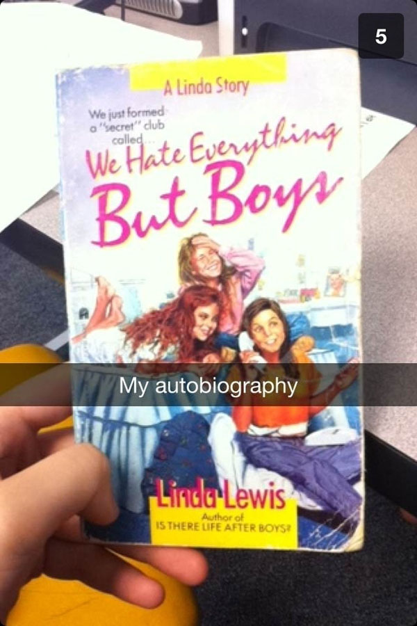 Linda Lewis, a person who is doing Snapchat just right, holding a book.