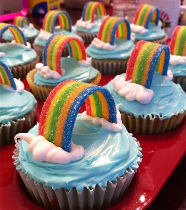 Rainbow cupcakes on a vibrant plate for food porn enthusiasts.