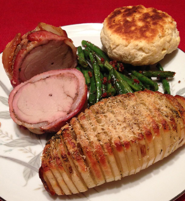 A mouthwatering photo of delicious roasted pork, green beans, and biscuits that will satisfy any food porn lover.