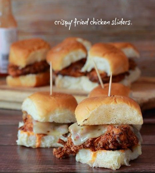 Game Day Grub Ideas: Chicken sliders displayed on a wooden cutting board.