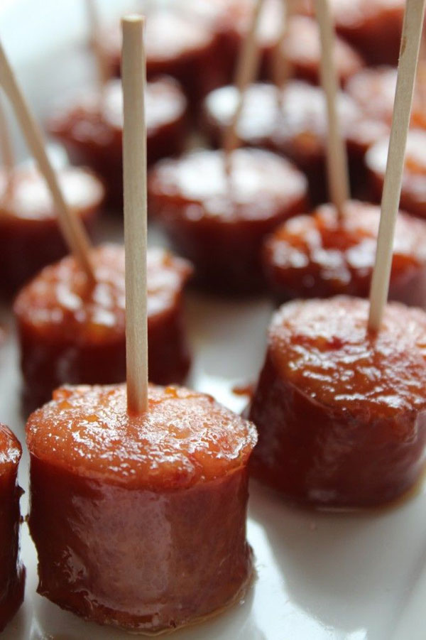Game day sausage skewers with toothpicks on a white plate.