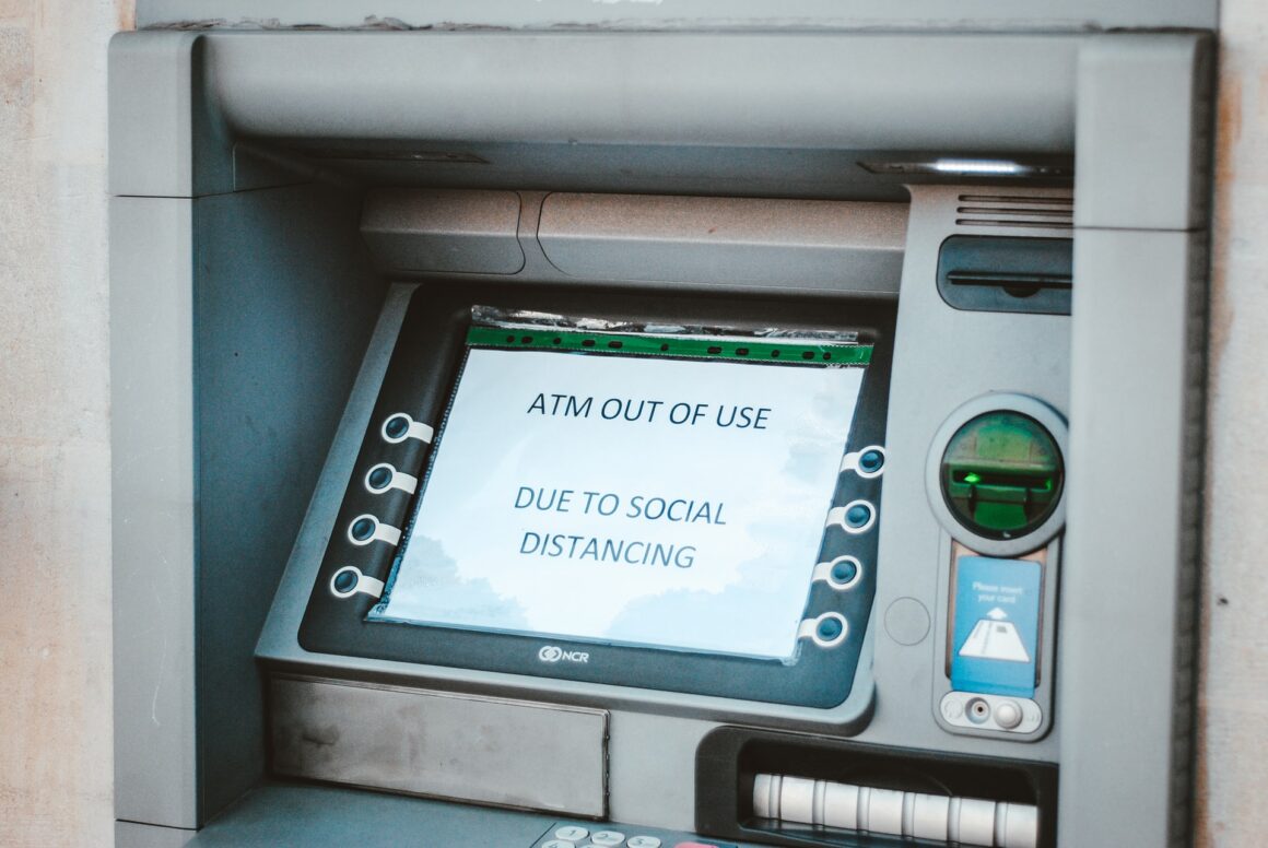 An ATM machine with a sign questioning COVID-19 media coverage.