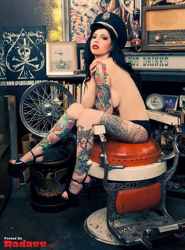 A tattooed woman enjoying the holidays in a barber chair.