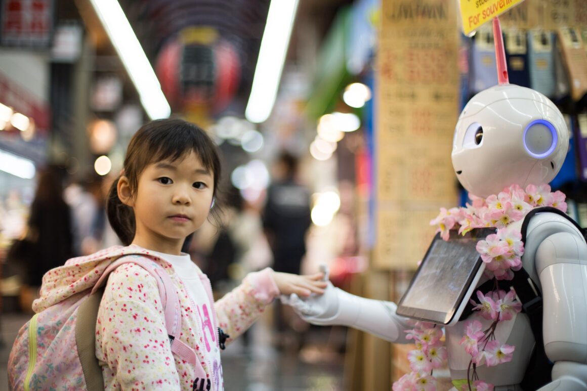 A young girl is interacting with a robot, shedding light on the issues with AI.