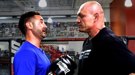 Two average men chatting in a ufc gym.