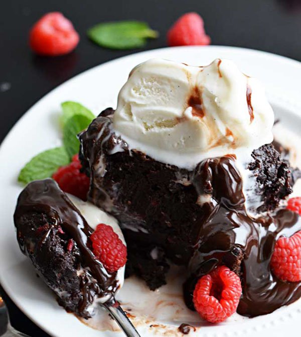 OMG, decadent chocolate cake piled high with creamy ice cream and juicy raspberries is pure food porn on a plate.