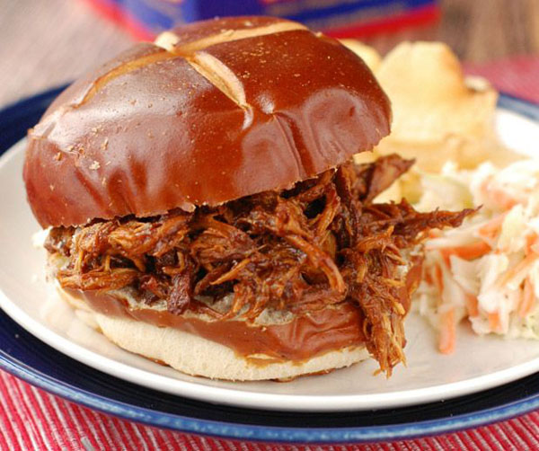 A mouthwatering pulled pork sandwich plated with indulgent coleslaw that's pure food porn.