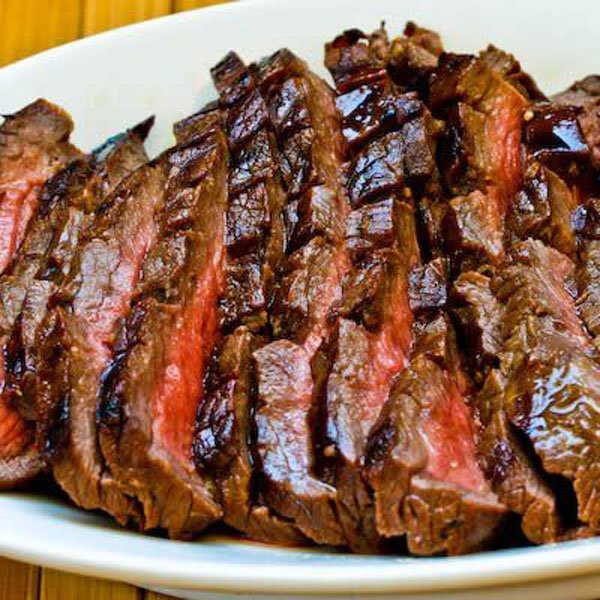 OM-F@cking-G It's a succulent, mouthwatering steak meticulously placed on a rustic wooden table.