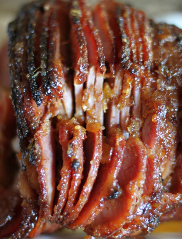 A mouthwatering close-up of a sliced ham on a plate, oozing with food porn goodness.