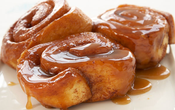 OM-F@cking-G Cinnamon rolls with caramel sauce on a white plate.