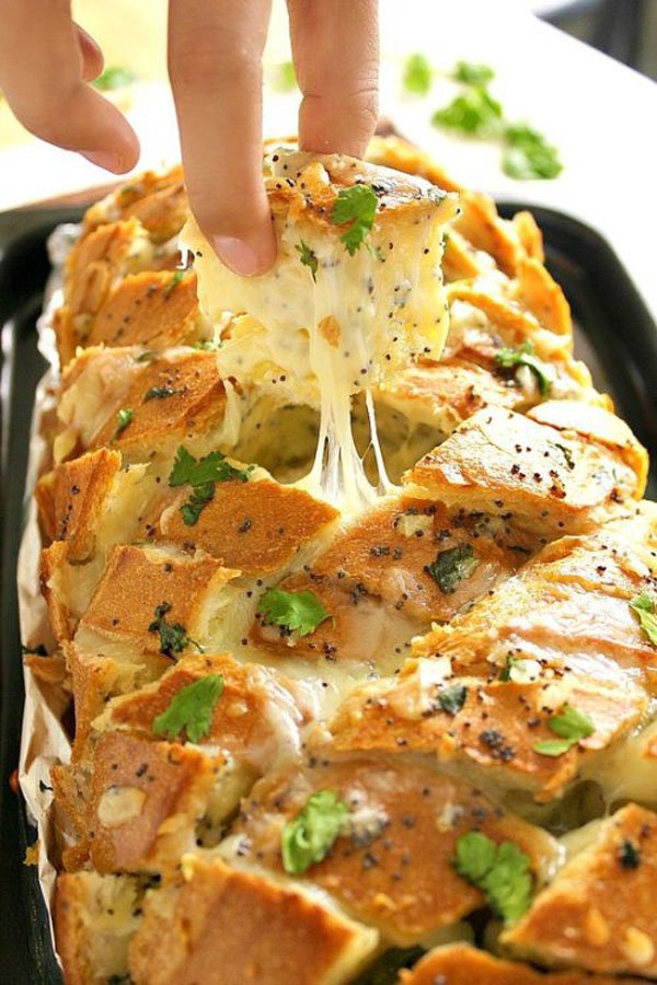 A person indulges in irresistible food porn by dipping bread into a pan.