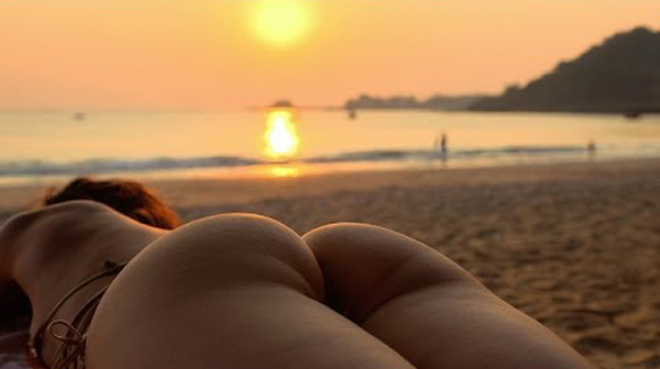 A woman enjoying the beach at sunset.