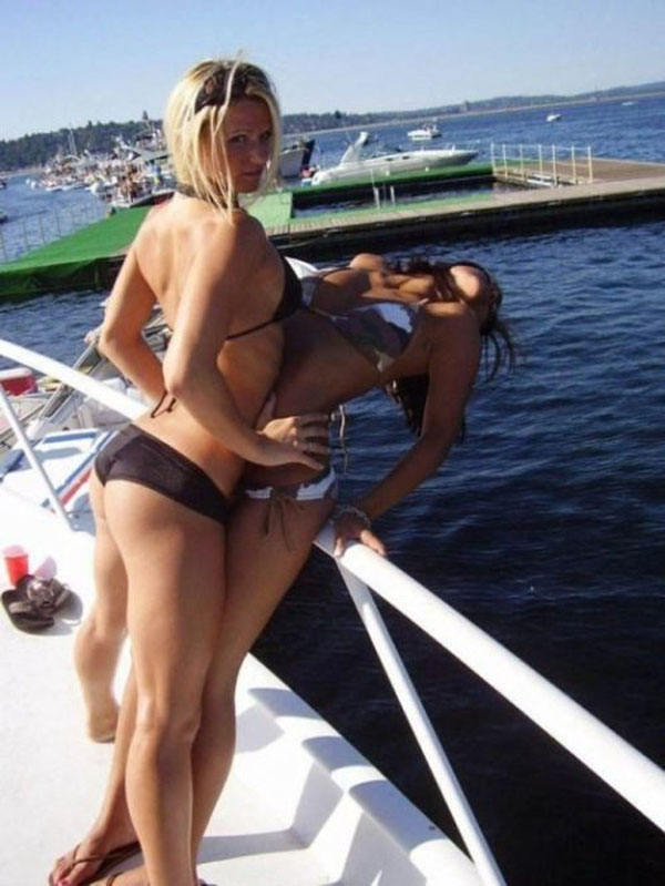 Two women in bikinis showcasing their summer looks on a boat.