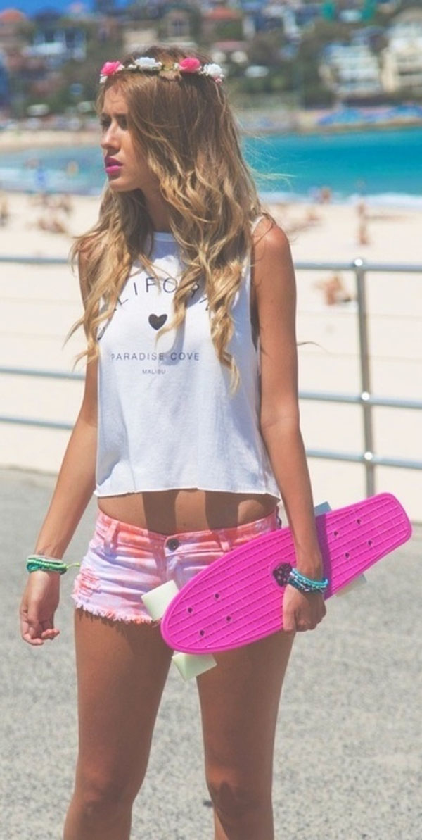 A young woman holding a pink skateboard on the beach, featured in The Best of Hot Girls of Summer 2014 (129 Pics).